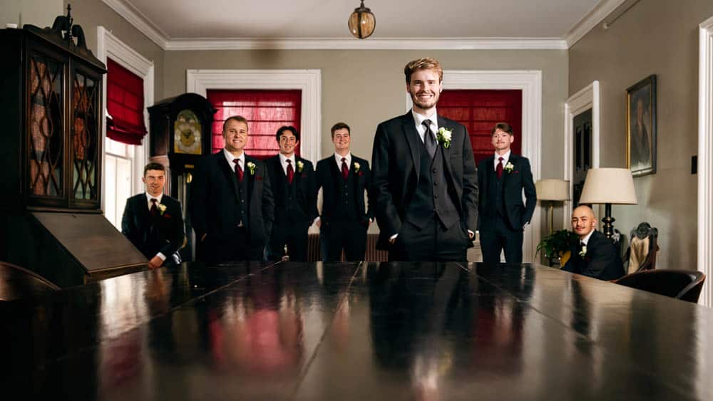 Groom and groomsmen posing in front of the conference table at the Collingswood Grand Ballroom Wedding.