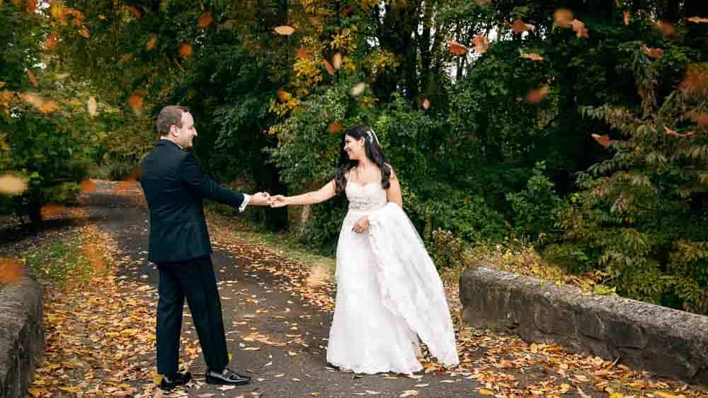 Bride and groom having fun underneath the falling leaves Legacy Club at Woodcrest in Cherry Hill NJ