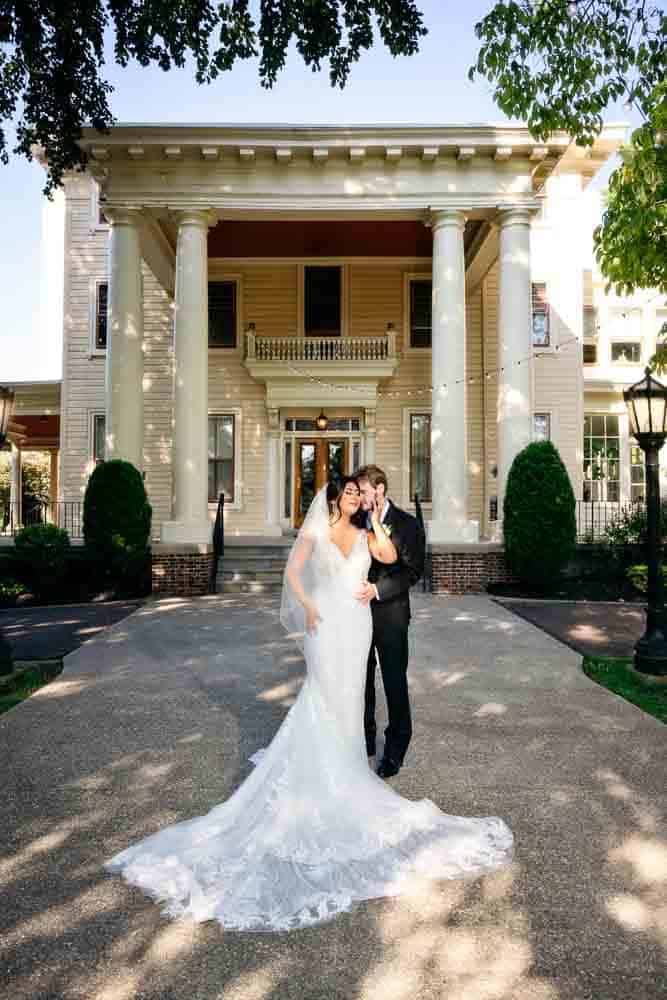 Bride and Groom posing in front of the main entrance to Collingswood Grand Ballroom Mansion