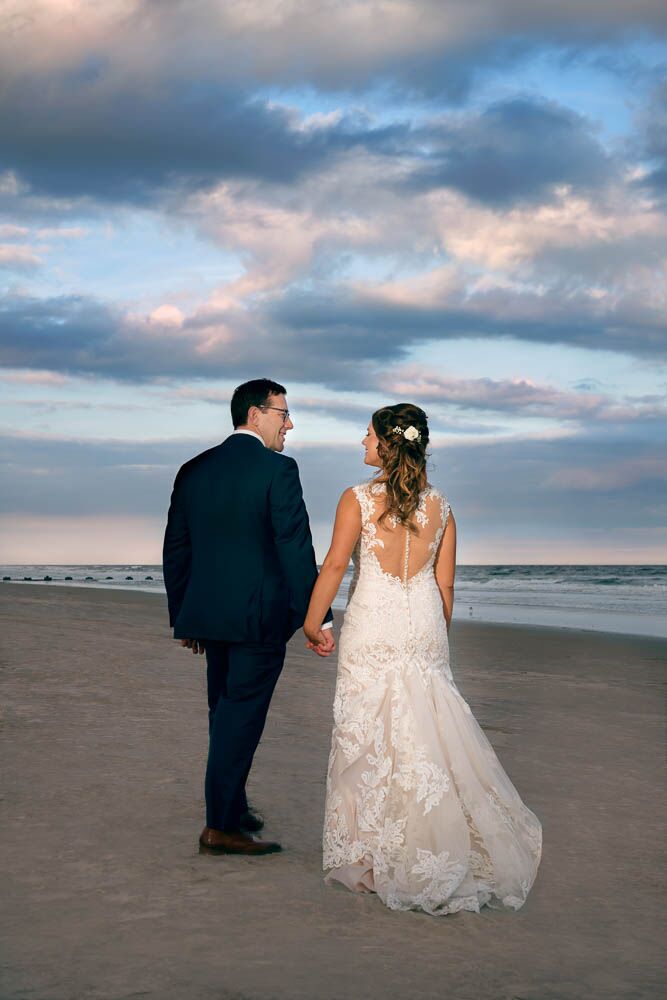 bride and groom strolling on the beach at ICONA Diamond Beach wedding.