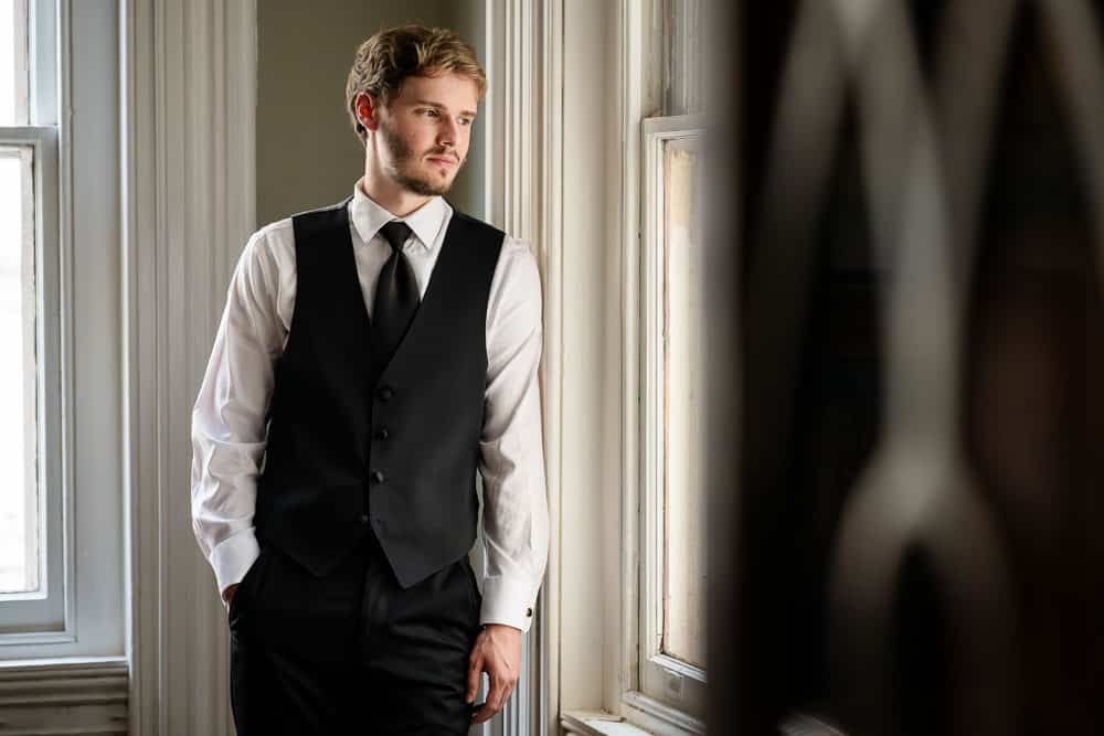 Groom staring out the window at the Collingswood Grand Ballroom Wedding.