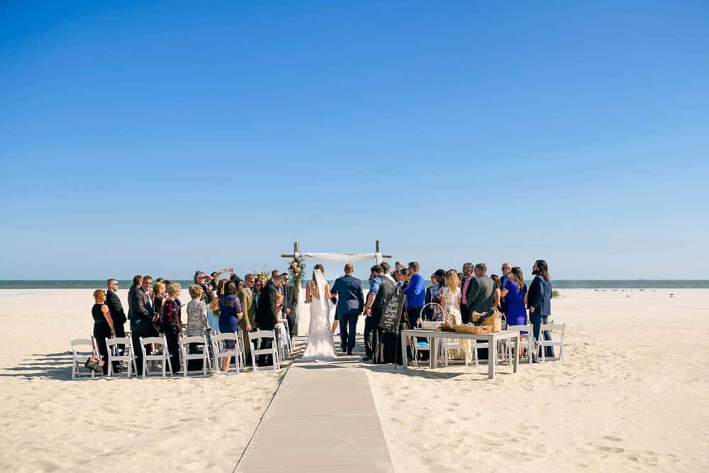 Bride and her father approach the officiant at the ICONA Diamond Beach Wedding.