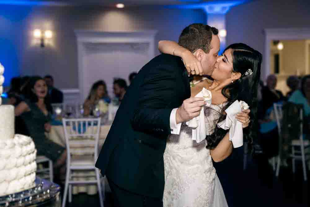 Bride and groom kiss after feeding each other some wedding cake Legacy Club at Woodcrest in Cherry Hill NJ