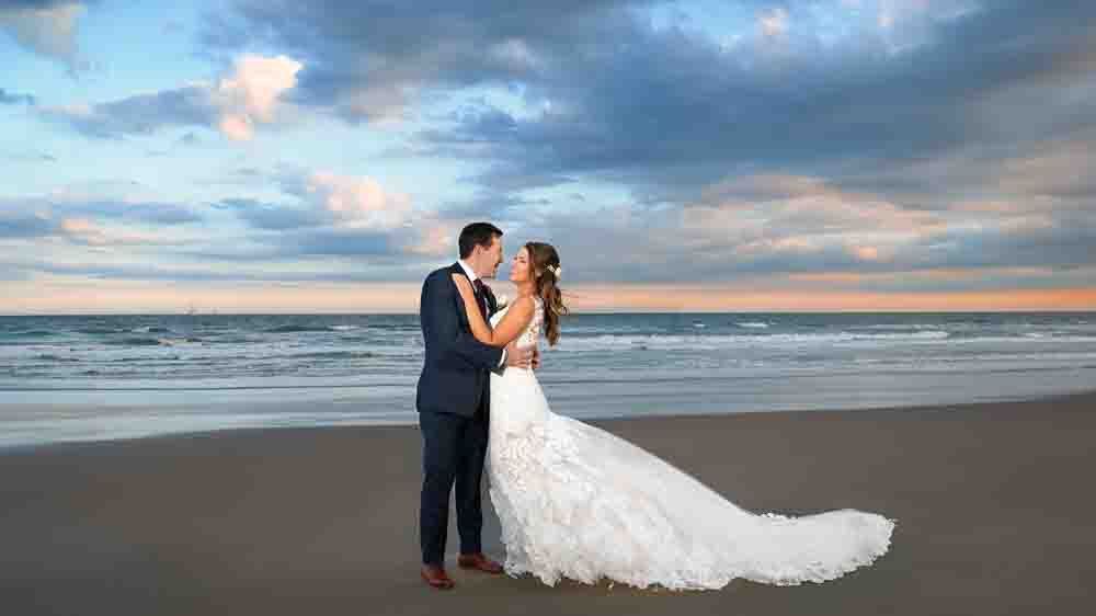 Bride and groom embracing on the beach after the sun sets at ICONA Diamond Beach wedding.