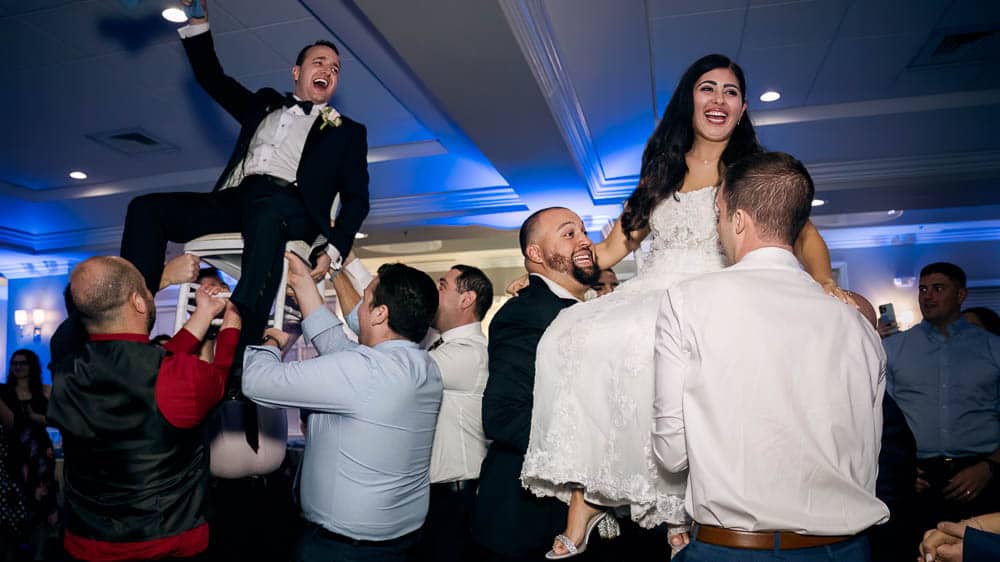 Bride and groom having fun during the traditional Hora Dance Legacy Club at Woodcrest in Cherry Hill NJ