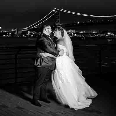 Frank and Maria outside the Adventure Aquarium wedding venue during the evening with the city of Philadelphia in the background.