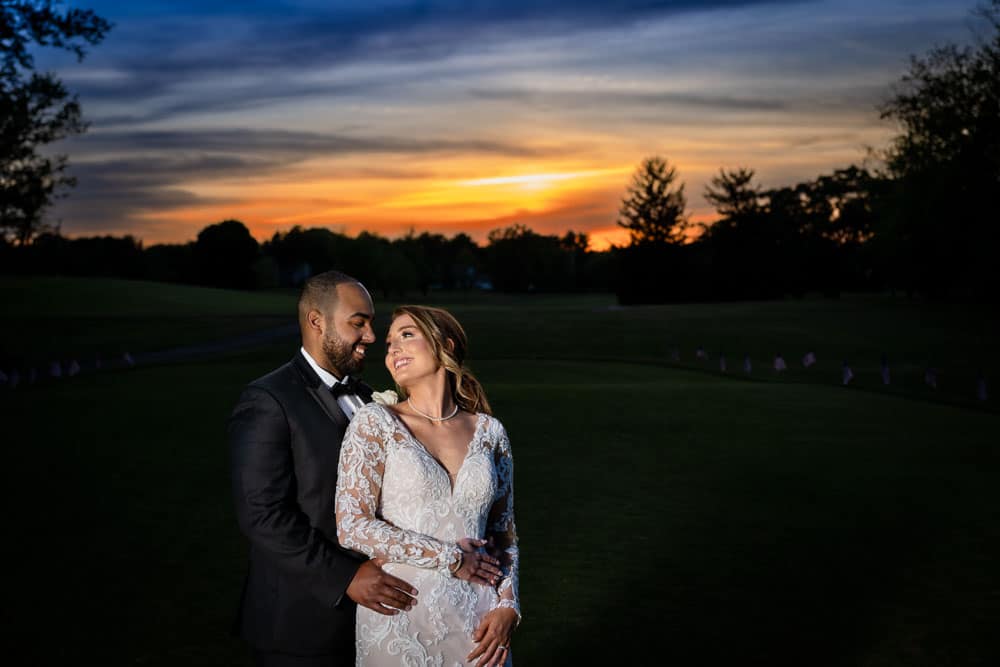 A beautiful sunset at Bogeys as the bride and groom embrace each other.