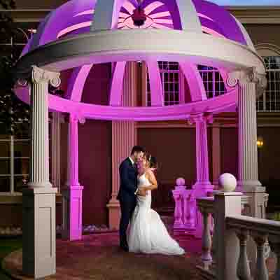 Laura and Michael embracing under the stone gazebo at Brigalias in Sicklerville NJ