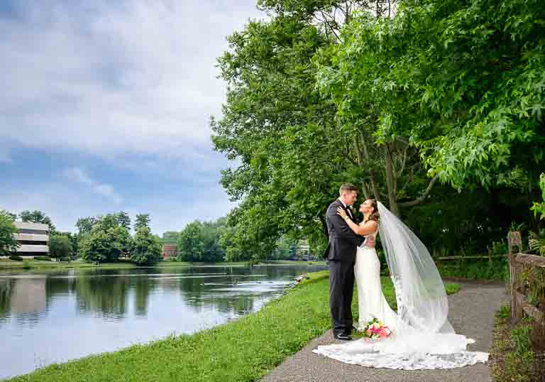 Couple posing by the lake before their wedding at Paris Caterers in Berlin NJ