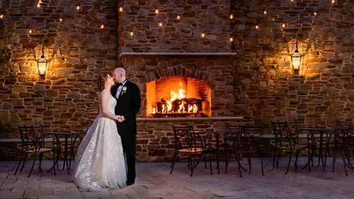 Bride and groom in the courtyard in front of the fireplace at The Madison in Riverside NJ