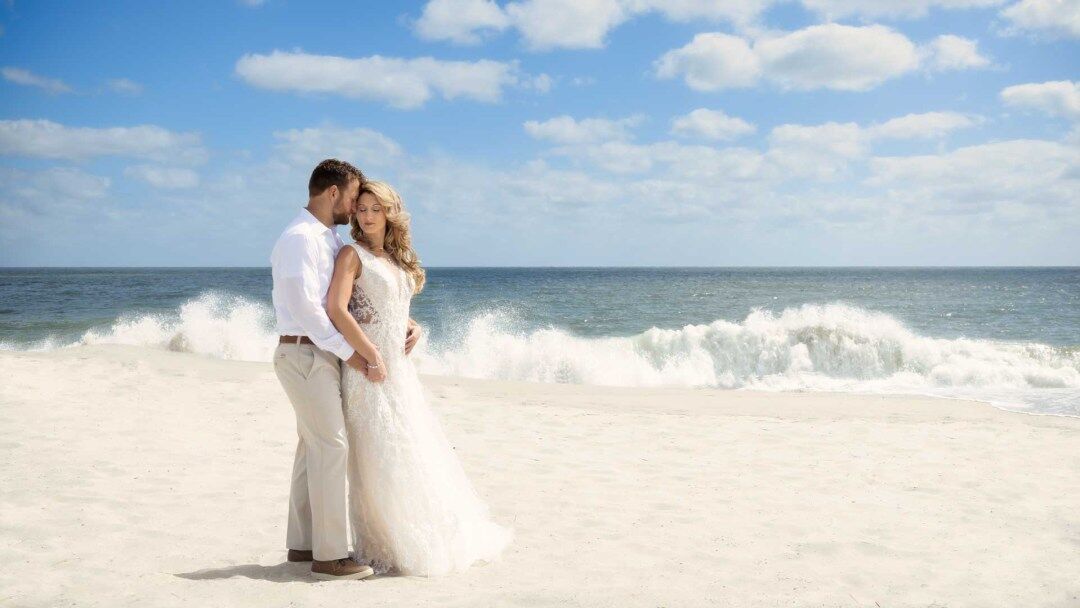 Bride and Groom embracing each other on the beach outside The Grand Hotel of Cape May